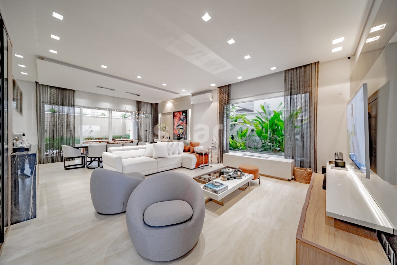 Living amplo em tons claros com jardim de inverno e piso de mármore