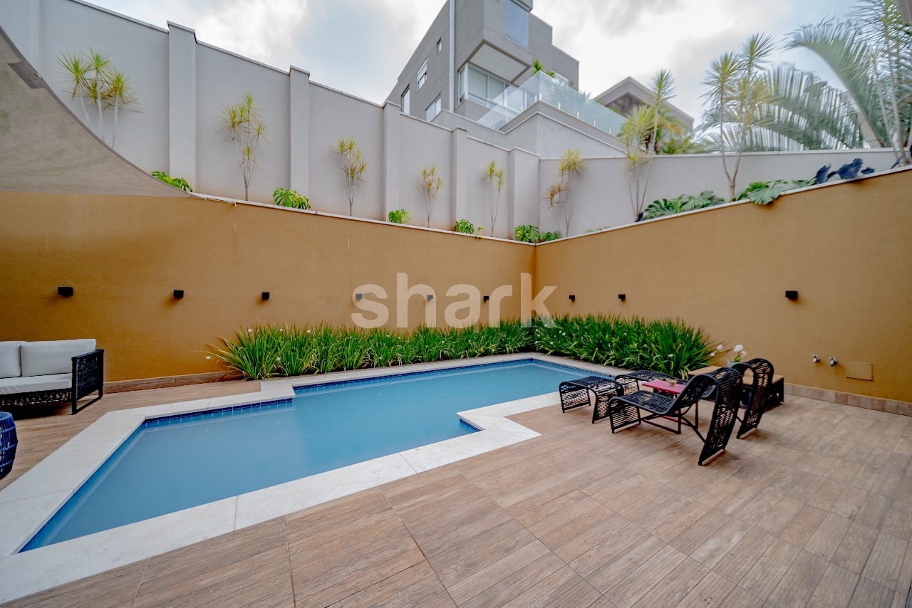 Piscina com jardim de folhagens e espreguiçadeiras