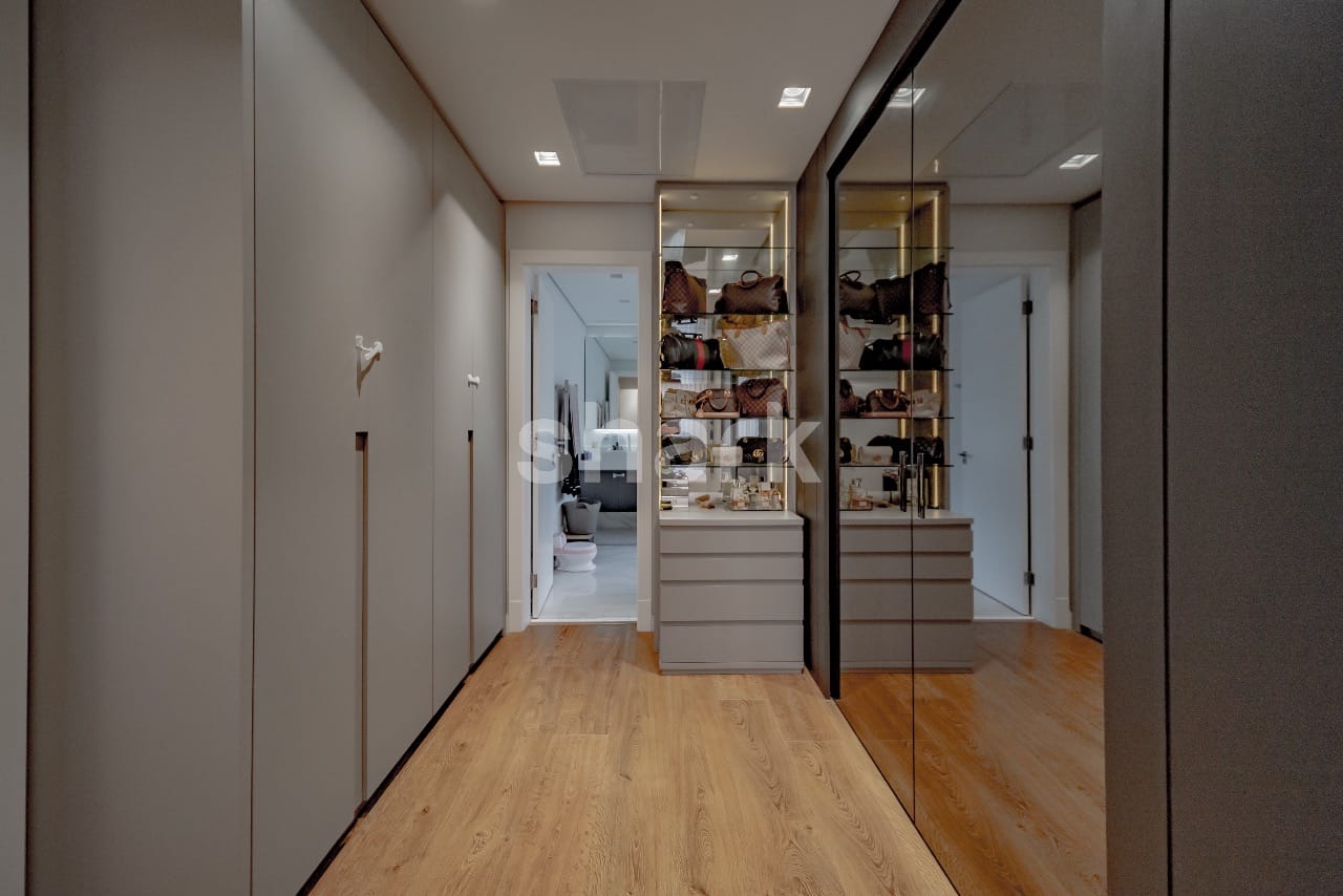 Closet com vitrine iluminada e piso de madeira