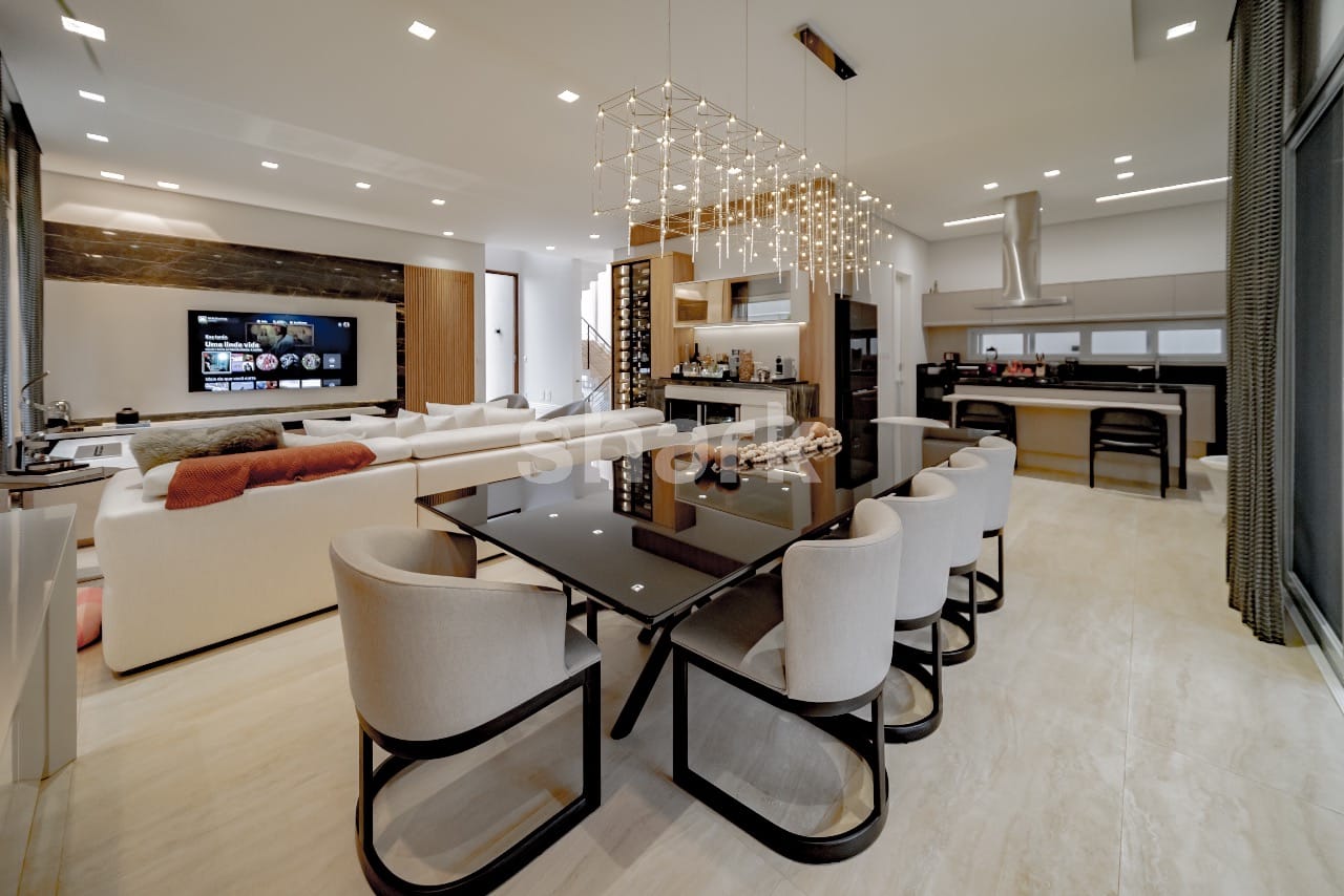 Sala de jantar com lustre de cristal, living integrado e adega ao fundo